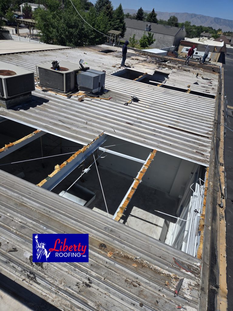 Fire-damaged commercial building roof during the tear-off and demolition phase in Provo, Utah.