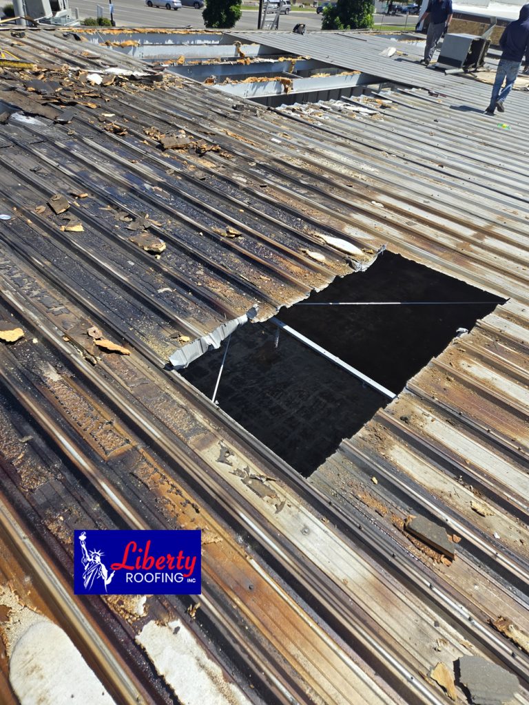 Liberty Roofing crew installing substantial new structural metal decking sheets on a fire-damaged Provo business.