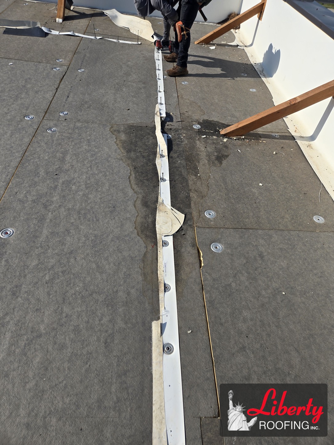 Liberty Roofing crew removing fasteners during a commercial roof replacement in Pleasant Grove