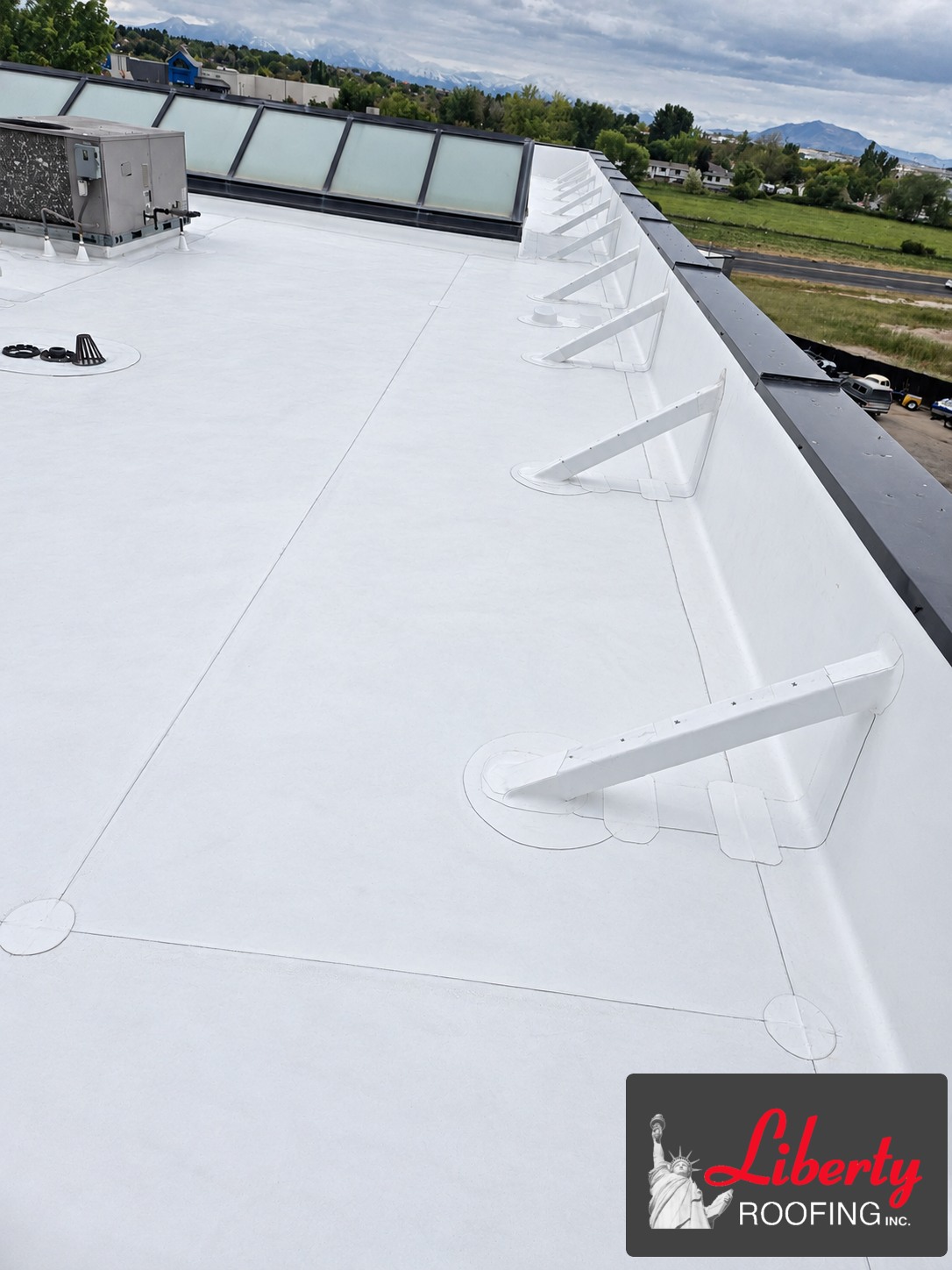 White Versico 60-mil TPO membrane along the roof perimeter and support bases