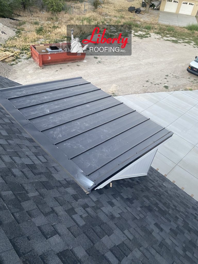 Standing seam metal roof panels above a white-sided dormer on a new residential construction project in American Fork